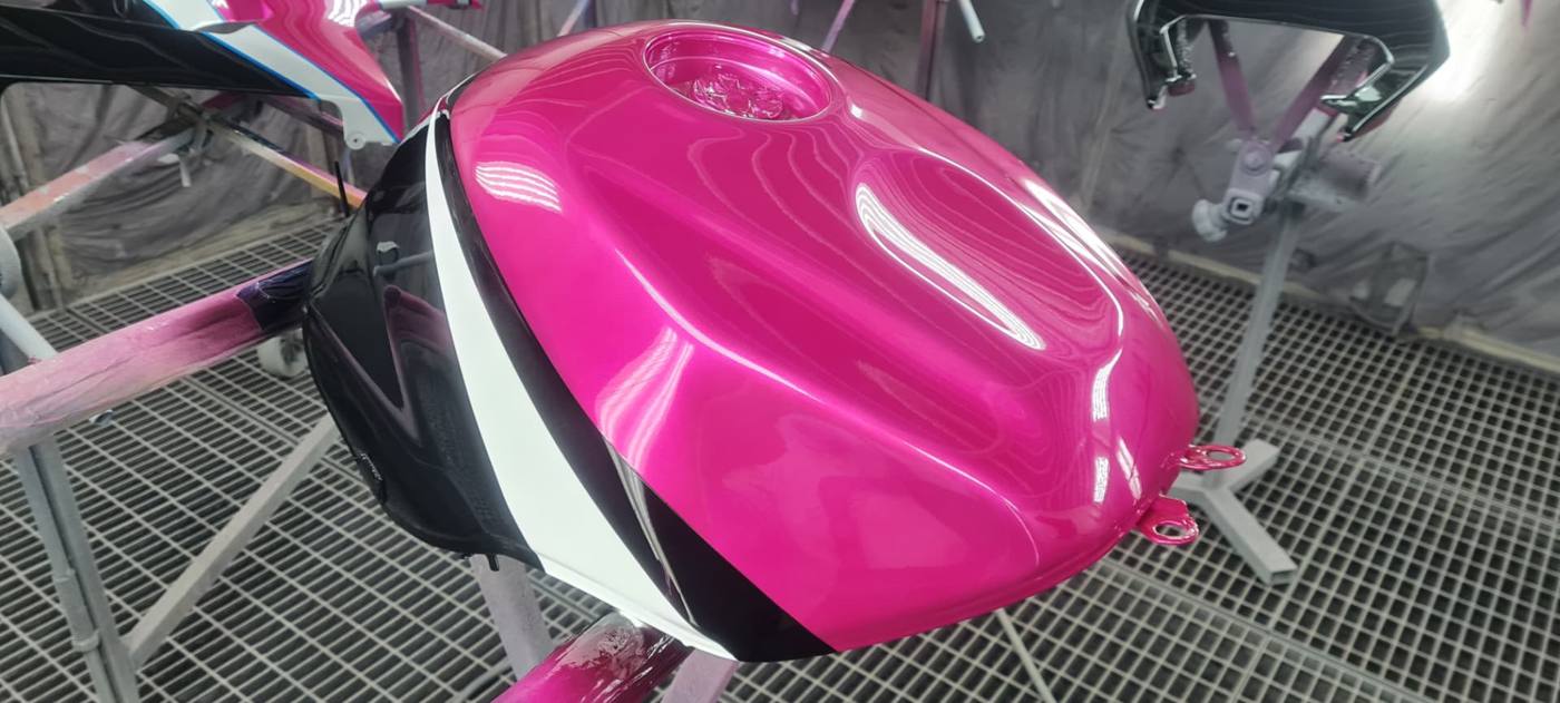 Motocyklová nádrž s ružovým, bielym a čiernym lakom